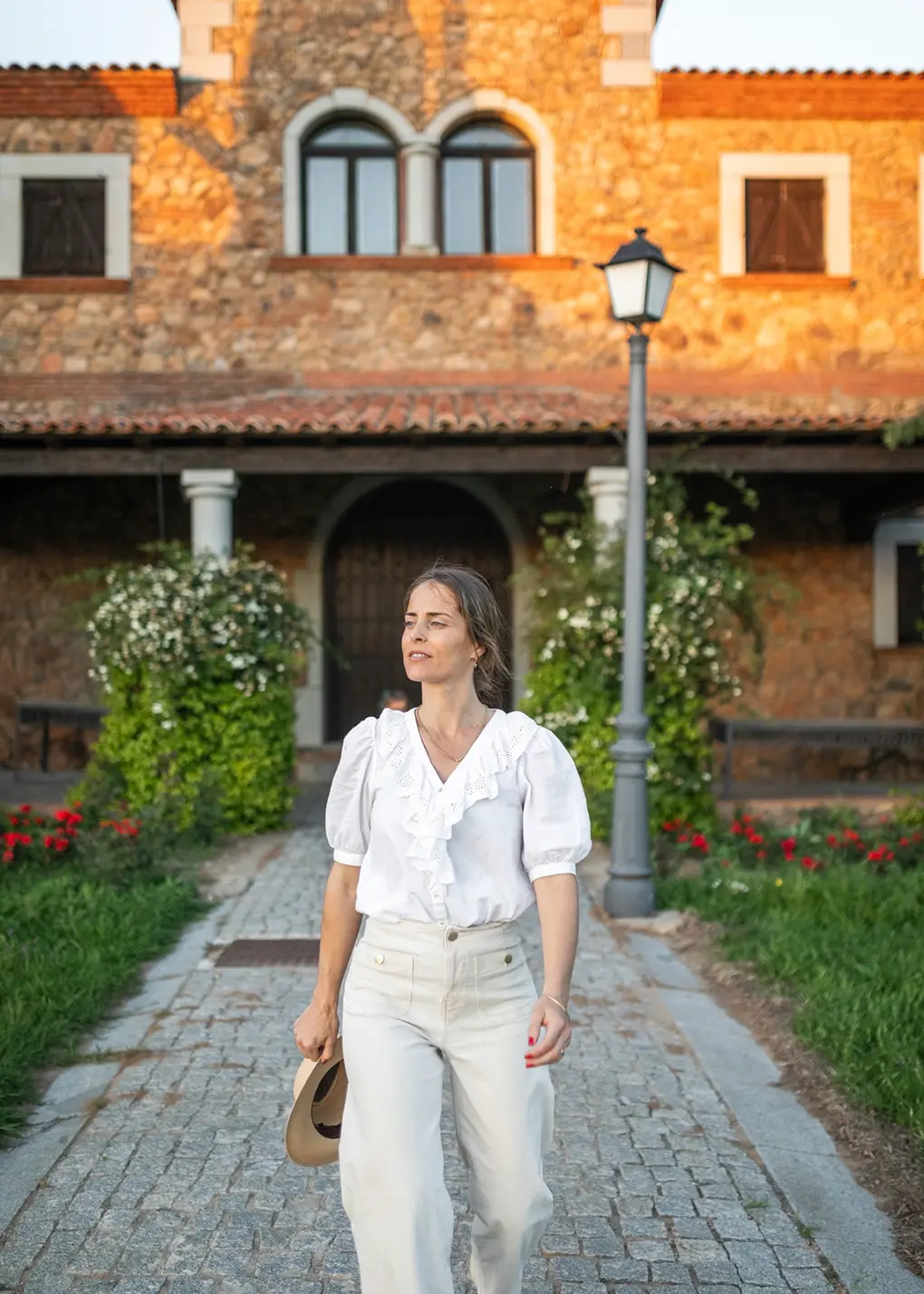 Frau vor mediterraner Villa