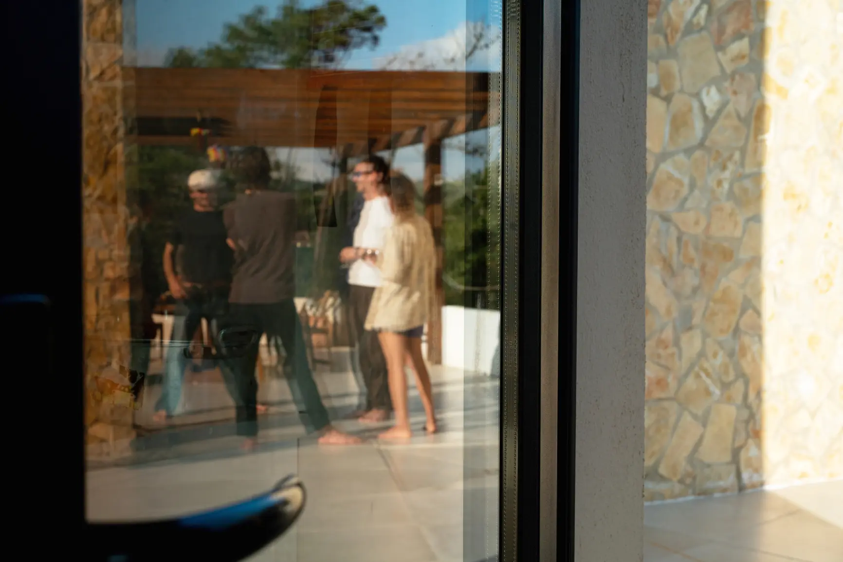 Personengruppe auf Terrasse spiegelt sich in Glastür